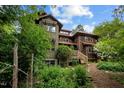 Stunning multi-level home nestled among lush greenery, with rustic wood and ample windows at 2917 Ericka Dr, Hillsborough, NC 27278