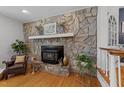 The cozy living room is enhanced by a stone fireplace, hardwood floors, and bright natural light at 305 Clarendon Cres, Raleigh, NC 27610