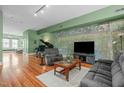 Spacious living room with hardwood floors, accent wall, piano, and comfortable seating arrangement at 323 W Main St # C, Durham, NC 27701