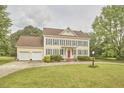 Traditional two-story home with yellow siding, grey shutters, a red door, and a long driveway at 3809 Victorian Grace Ln, Apex, NC 27539