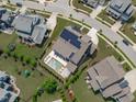 Aerial view of a home with a pool, pergola, solar panels, and a lush green lawn in a well-maintained neighborhood at 400 Chickasaw Plum Dr, Holly Springs, NC 27540