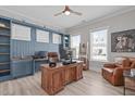 Office with a built-in desk, wood desk, two windows, and an accent wall at 400 Chickasaw Plum Dr, Holly Springs, NC 27540