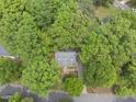 An aerial view of a house surrounded by lush, mature trees in a vibrant, green neighborhood at 404 Trappers Run Dr, Cary, NC 27513