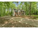 Long concrete driveway leading to a brick home surrounded by lush trees and greenery at 4041 Brook Cross Dr, Apex, NC 27539