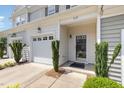 Inviting front entrance with a black framed glass door, one-car garage, and manicured landscaping at 412 Stone Flower Ln, Raleigh, NC 27603