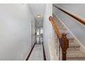 Bright hallway with staircase, light gray walls, dark wood floors, and a patterned rug at 412 Stone Flower Ln, Raleigh, NC 27603