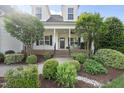 Inviting front porch with landscaping featuring shrubs and trees leading to the entrance of the beautiful home at 45 Mill Cir, Clayton, NC 27527