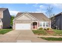 Charming home with stone accents, a two-car garage, a well-maintained yard, and a welcoming red front door at 46 S Great White Way, Clayton, NC 27527