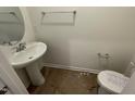 Compact powder room featuring a pedestal sink, oval mirror, toilet, and chrome hardware at 505 Eastwood St, Durham, NC 27704