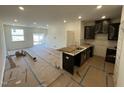 Open-concept living space with kitchen featuring dark cabinets and a stainless steel sink, connected to a living area at 505 Eastwood St, Durham, NC 27704