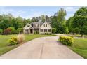 Attractive home featuring a long driveway surrounded by lush greenery and landscaping at 5209 Thistleby Rd, Fuquay Varina, NC 27526