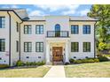 Stately white building entrance featuring a wooden door, balcony, and classic architectural details at 607 Smedes Place # B, Raleigh, NC 27605