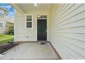 Inviting front porch featuring brick trim, siding, and a black front door at 704 Moonbeam Dr, Raleigh, NC 27603