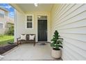 Charming front porch featuring a bench, plant, and black front door of this lovely home at 704 Moonbeam Dr, Raleigh, NC 27603