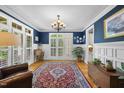 Sophisticated living room with hardwood floors, blue accent wall, and window shutters at 716 Streamwood Dr, Holly Springs, NC 27540