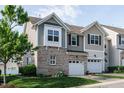 Charming townhome featuring a front yard, garage, and beautiful architectural details at 7229 Terregles Dr, Raleigh, NC 27617