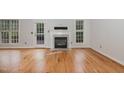 Bright living room featuring hardwood floors, a fireplace, and abundant natural light from multiple windows at 7940 Milltrace Run, Raleigh, NC 27615