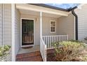 Close-up of the front porch featuring a dark front door and white railing at 1021 S Fieldhaven Dr, Fuquay Varina, NC 27526