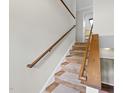 Interior staircase featuring carpeted steps and wood handrails, leading to the upper level of the home at 104 Farnham Ct, Garner, NC 27529