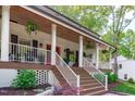 Inviting front porch with white railing, red door, and ample space for outdoor relaxation at 1107 Daleland Dr, Raleigh, NC 27612