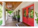 Covered porch with red double doors, ceiling fan, and space for seating at 1107 Daleland Dr, Raleigh, NC 27612