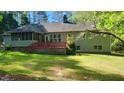 Spacious backyard featuring a deck, screened-in porch, and lush greenery at 113 Colonial Dr, Wendell, NC 27591
