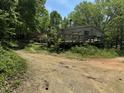 Home with a cozy deck, set back from the road, nestled among lush trees and greenery at 113 Pineview Dr, Louisburg, NC 27549