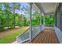 Spacious covered front porch offers serene views of the surrounding wooded landscape at 123 Alan Ln, Clayton, NC 27520