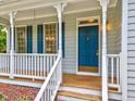 Inviting front porch with white railing, blue door, and wood flooring detail at 123 Alan Ln, Clayton, NC 27520