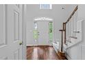 Bright foyer featuring hardwood floors, staircase, and a glass paneled front door at 1245 Torchlight Way, Raleigh, NC 27603