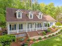 Beautiful single story home with inviting front porch, manicured garden, and classic architectural details at 1245 Torchlight Way, Raleigh, NC 27603
