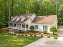 An exterior view of a single story home with lush lawn and garden and a long driveway at 1245 Torchlight Way, Raleigh, NC 27603