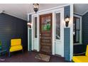 Inviting front porch with a wooden door, detailed sidelights, and stylish outdoor lighting at 130 N Bloodworth St, Raleigh, NC 27601