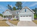 Inviting exterior view of a home with a cozy front porch, lush landscaping, and an attached garage at 1427 Bungalow Ave, Durham, NC 27703