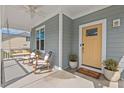 Relaxing front porch with rocking chairs, porch swing, and a vibrant yellow front door at 1427 Bungalow Ave, Durham, NC 27703