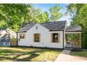 Inviting home showcasing a covered porch and wood shutters, surrounded by vibrant greenery and a well-maintained lawn at 1513 Fairfax Rd, Durham, NC 27701