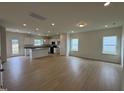 Open living room with wood floors, white walls, recessed lights and views into the kitchen at 152 Bruce Dr, Dunn, NC 28334