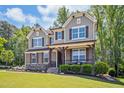 A Craftsman-style house exhibits a lush lawn and a covered porch, enhanced by tasteful stone and siding accents at 1557 Tice Hurst Ln, Apex, NC 27502