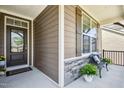 Cozy front porch with stone accents, adorned with seating and greenery for a welcoming entrance to the home at 1557 Tice Hurst Ln, Apex, NC 27502