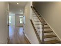 Bright entryway with wood-look flooring, a staircase with white railings, and a view into the spacious living areas at 1565 Wendell Valley Blvd, Wendell, NC 27591