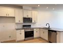 Bright, modern kitchen with stainless steel appliances, granite countertops, white cabinetry, and wood-look flooring at 1565 Wendell Valley Blvd, Wendell, NC 27591