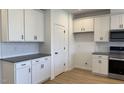 Well-lit kitchen featuring white cabinets, granite countertops, stainless steel appliances, and stylish backsplash at 1565 Wendell Valley Blvd, Wendell, NC 27591