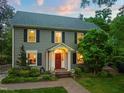 Charming two-story home with a classic red door, black shutters, and beautifully landscaped front yard at 1603 Hermitage Ct, Durham, NC 27707