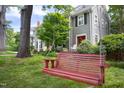 Relaxing red porch swing in the shade next to a gray house with a red door at 1603 Hermitage Ct, Durham, NC 27707