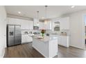 Modern kitchen with white cabinetry, stainless steel appliances, and a granite-topped island at 176 Belleforte Park Cir, Garner, NC 27529