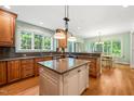 Gourmet kitchen features granite countertops, hardwood floors, a kitchen island, and ample natural light at 19002 Stone Brk, Chapel Hill, NC 27517