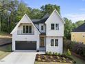 Charming two-story home with landscaped yard and a black garage door at 1904 French Dr, Raleigh, NC 27612