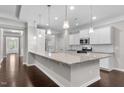 Modern kitchen featuring granite countertops, stainless steel appliances, white cabinetry, and hardwood floors at 2005 Delphi Way, Wake Forest, NC 27587
