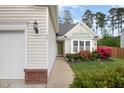 Inviting home featuring a walkway leading to a green front door and a meticulously maintained front yard at 205 Braxcarr St, Holly Springs, NC 27540