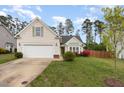 Inviting home featuring a well-maintained lawn, and an attached two-car garage at 205 Braxcarr St, Holly Springs, NC 27540